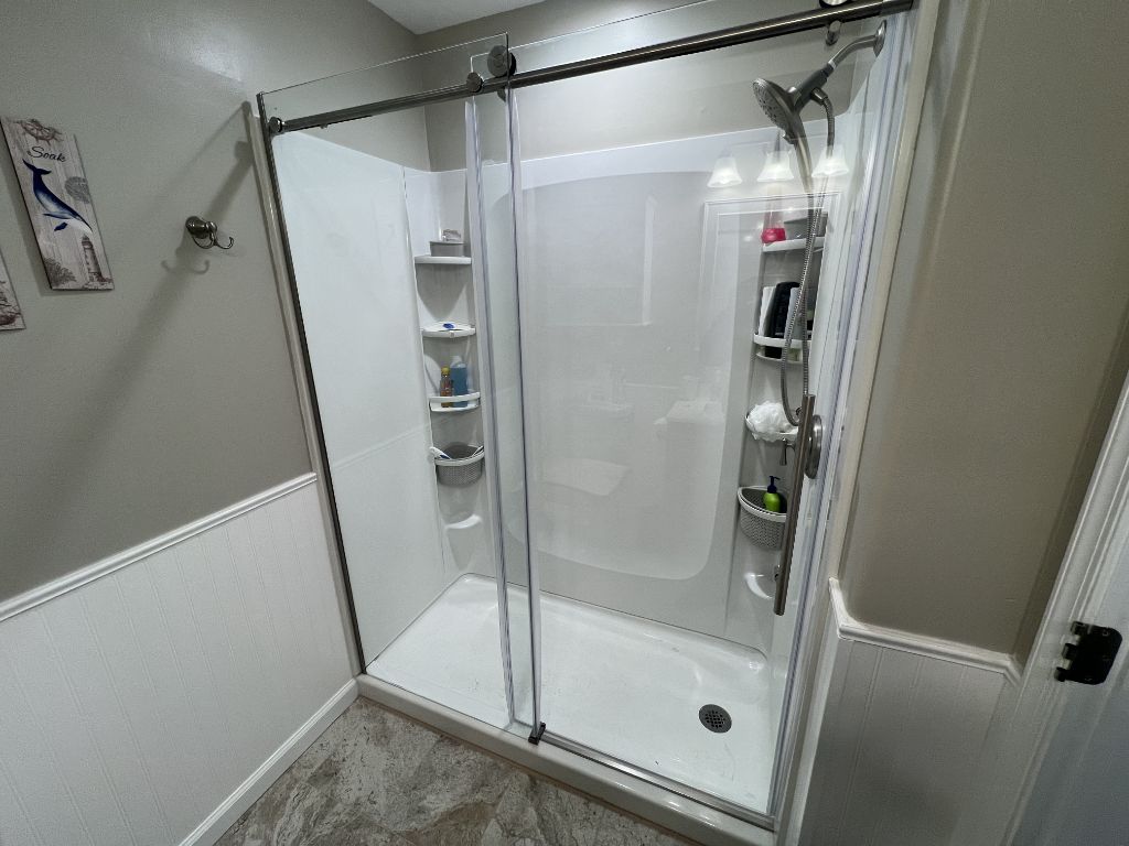 Sliding shower door on white enclosure